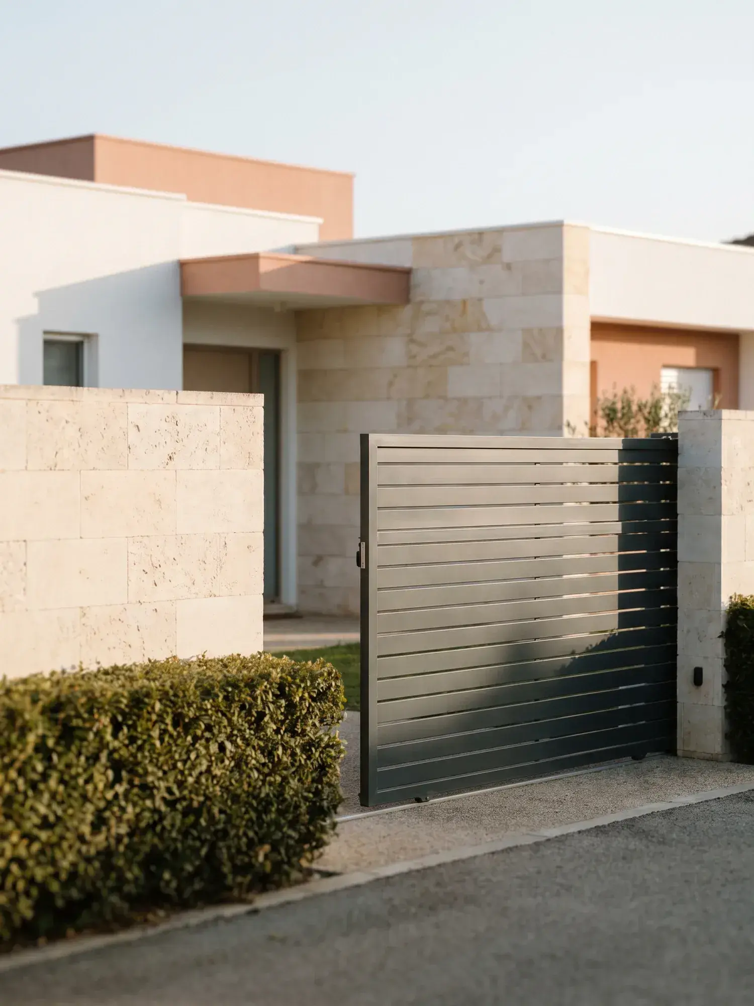 Portail coulissant en aluminium à lames horizontales devant une maison contemporaine