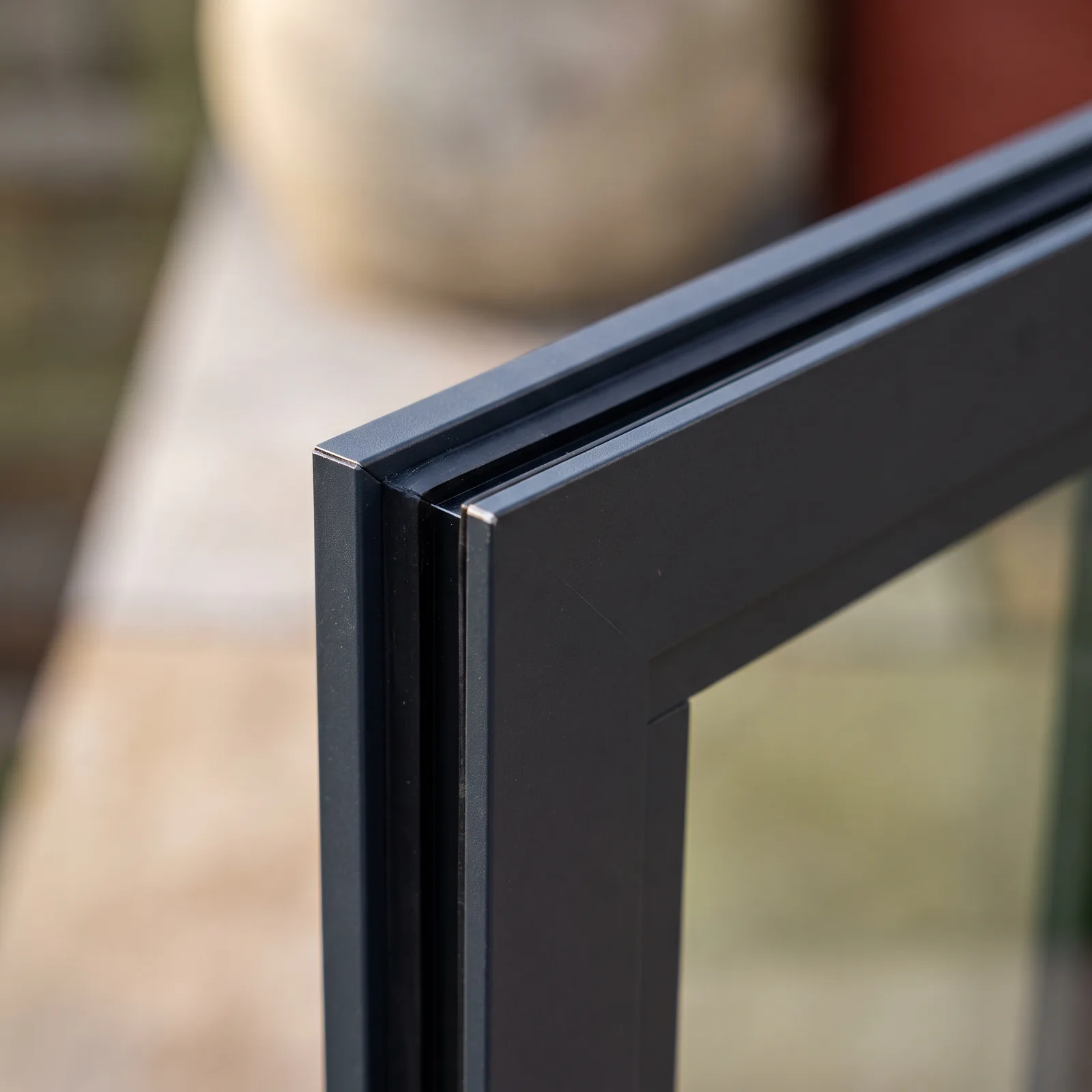 Gros plan sur l'angle d'un profilé de fenêtre en aluminium laqué anthracite